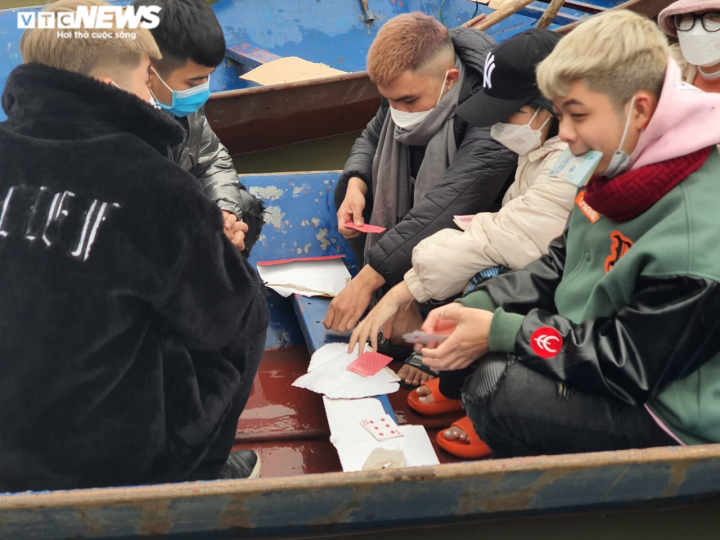 Mặc dù Ban Quản lý Khu di tích thắng cảnh Hương Sơn khuyến cáo người dân không đánh bài khi tham quan di tích, nhưng theo ghi nhận của PV, một số du khách vẫn tổ chức đánh bài ăn tiền ngay trên đò. (Ảnh: VTC News)