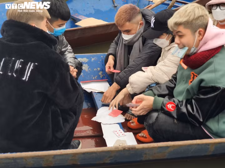 Mặc dù Ban Quản lý Khu di tích thắng cảnh Hương Sơn khuyến cáo người dân không đánh bài khi tham quan di tích, nhưng theo ghi nhận của PV, một số du khách vẫn tổ chức đánh bài ăn tiền ngay trên đò. (Ảnh: VTC News)