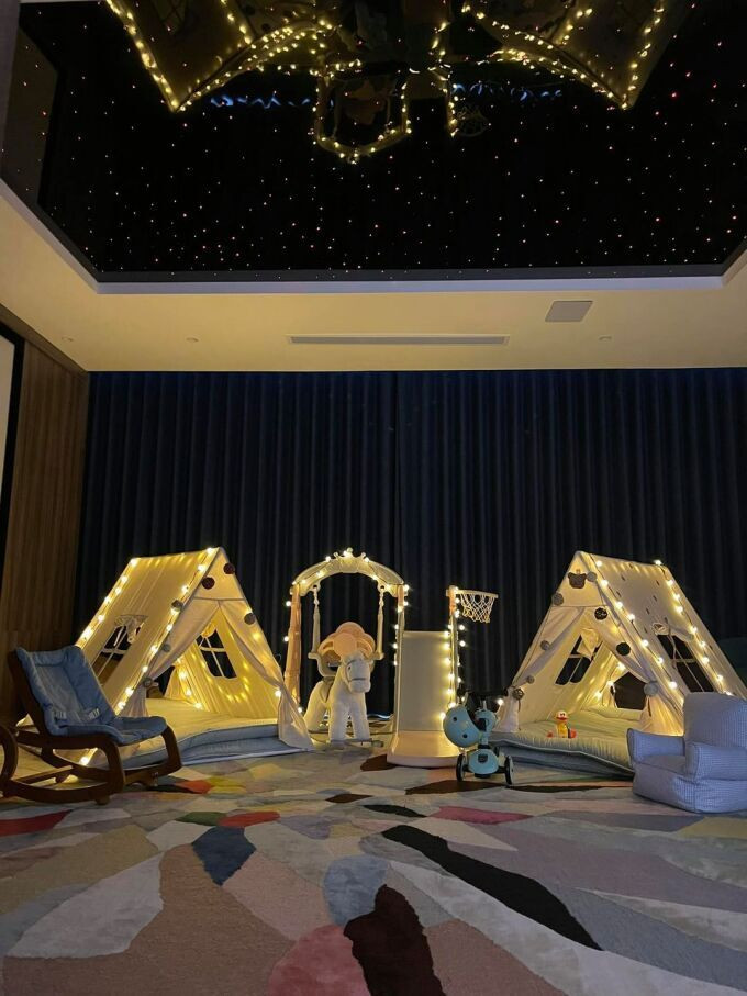 Cách đây không lâu, đại gia phố núi dựng khu lều trại cho hai con vui chơi tại nhà. Chỗ cắm trại được lót thảm, xung quanh có cầu trượt, xích đu, ghế... Trần nhà được anh thiết kế như bầu trời. Ảnh: FBNV