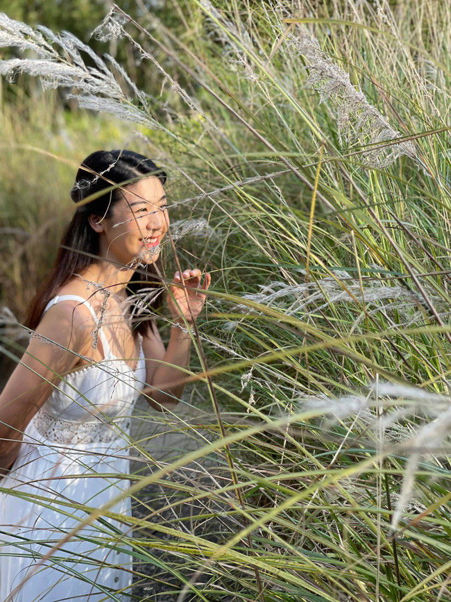 Vừa qua, trên trang cá nhân, Huỳnh Lý Đông Phương đăng tải bức hình chụp ở bãi cỏ lau với chiếc váy trắng thơ mộng khiến dân mạng xuýt xoa. Ảnh: FBNV