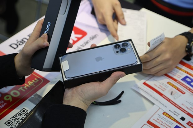 Năm nay, để hạn chế tình trạng đầu cơ - mua đi bán lại kiếm lời, nhiều hệ thống bán lẻ yêu cầu khách phải mở hộp iPhone 13 và kích hoạt ngay tại cửa hàng. Ảnh: Vietnam+