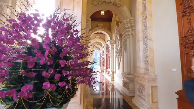 Hành lang dài, rộng với tường trang trí hoa văn cầu kỳ.