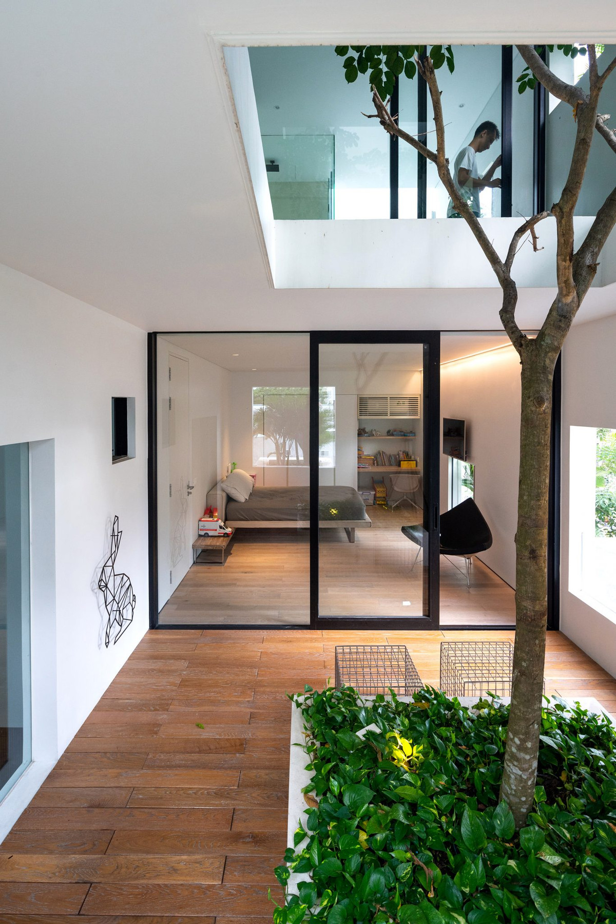 Căn nhà được chia làm đôi. Nửa đầu dành cho nắng, gió, nước và cây cối hoặc đơn giản là những khoảng không gian trống, nửa còn lại dành cho sinh hoạt gia đình với những tiện ích tối thiểu.