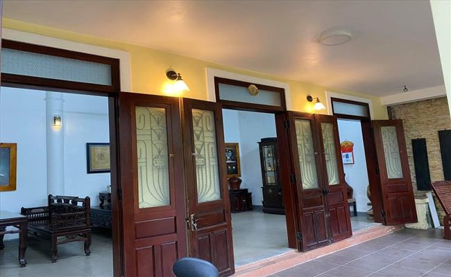 Phía trước căn nhà có nhiều gian cửa rộng. Tất cả đều được làm từ gỗ tự nhiên và lắp đèn vàng tạo cảm giác cổ xưa. Ảnh: Dân Việt