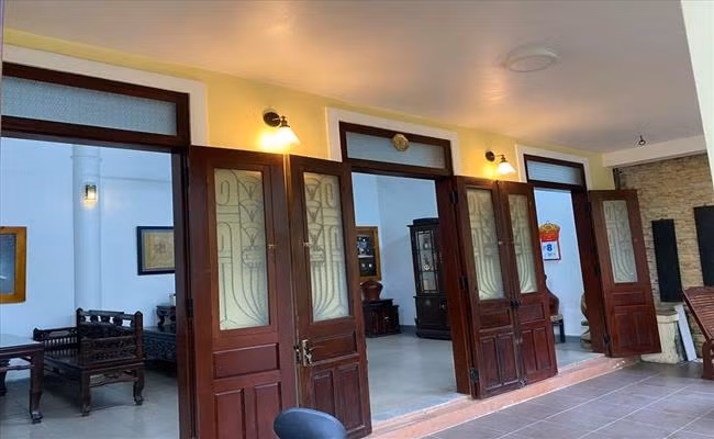 Phía trước căn nhà có nhiều gian cửa rộng. Tất cả đều được làm từ gỗ tự nhiên và lắp đèn vàng tạo cảm giác cổ xưa. Ảnh: Dân Việt