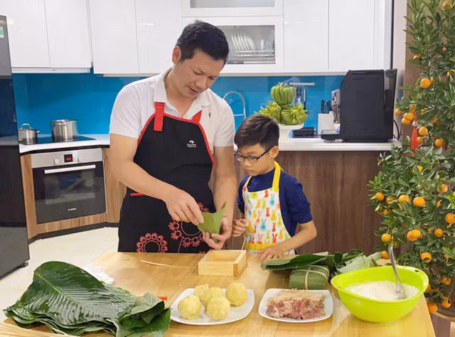 Shark Hưng và con trai trổ tài gói bánh chưng ngày Tết. Ảnh: FBNV