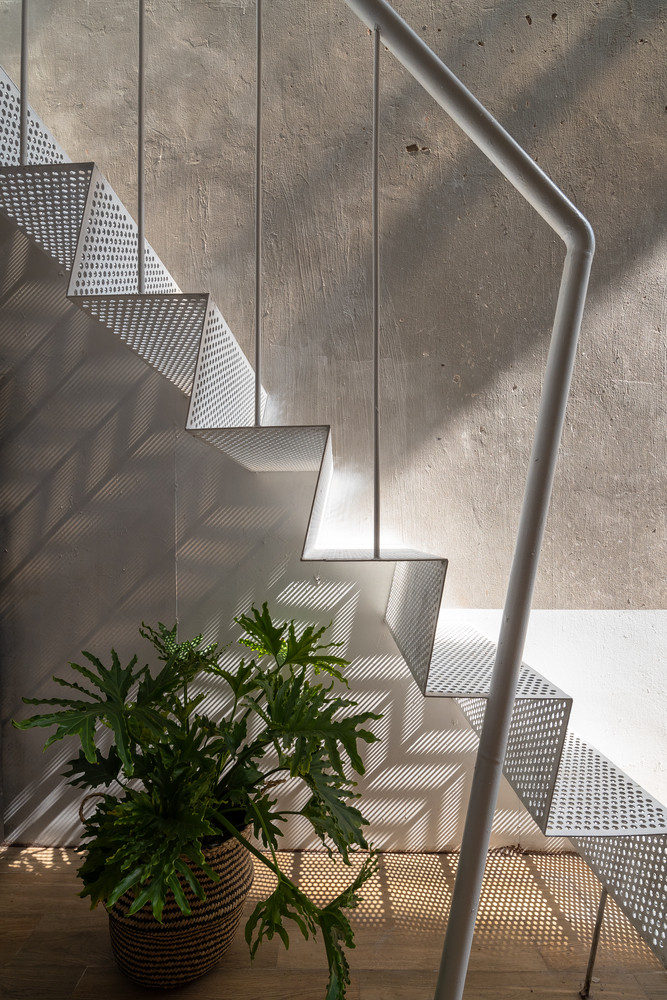 Bằng cách sử dụng cầu thang sắt đục lỗ kết nối tầng 1 và tầng 2, ánh sáng tự nhiên có thể tràn vào bên trong nhà bếp vào ban ngày.