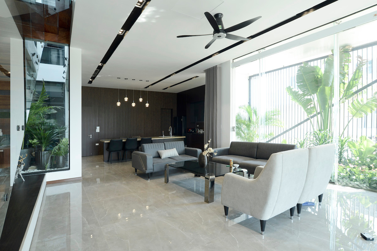 Bên phía hướng Tây, các khoảng lùi nhỏ như sân ướt, cây xanh khiến không gian chức năng bên trong không bị ảnh hưởng bởi nắng gắt. Với cách bố trí như vậy, không gian phòng khách sẽ đón được những ánh nắng hoàng hôn cuối chiều qua những tán lá.