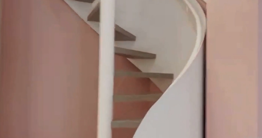 Cầu thang dẫn lên tầng 2 uốn lượn mềm mại. Ảnh chụp màn hình