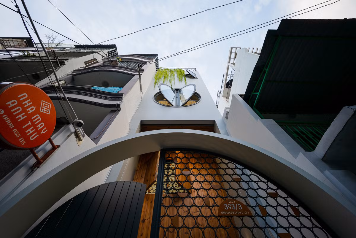 Để tạo sự mềm mại cho nhà phố và con hẻm nhỏ, kiến trúc sư thiết kế những ô cửa sổ hình tròn và bán nguyệt. Khi mở, hai cánh cửa sổ tầng ba tạo hình giống trái tim, khiến công trình mang biệt danh "ngôi nhà có hình trái tim".