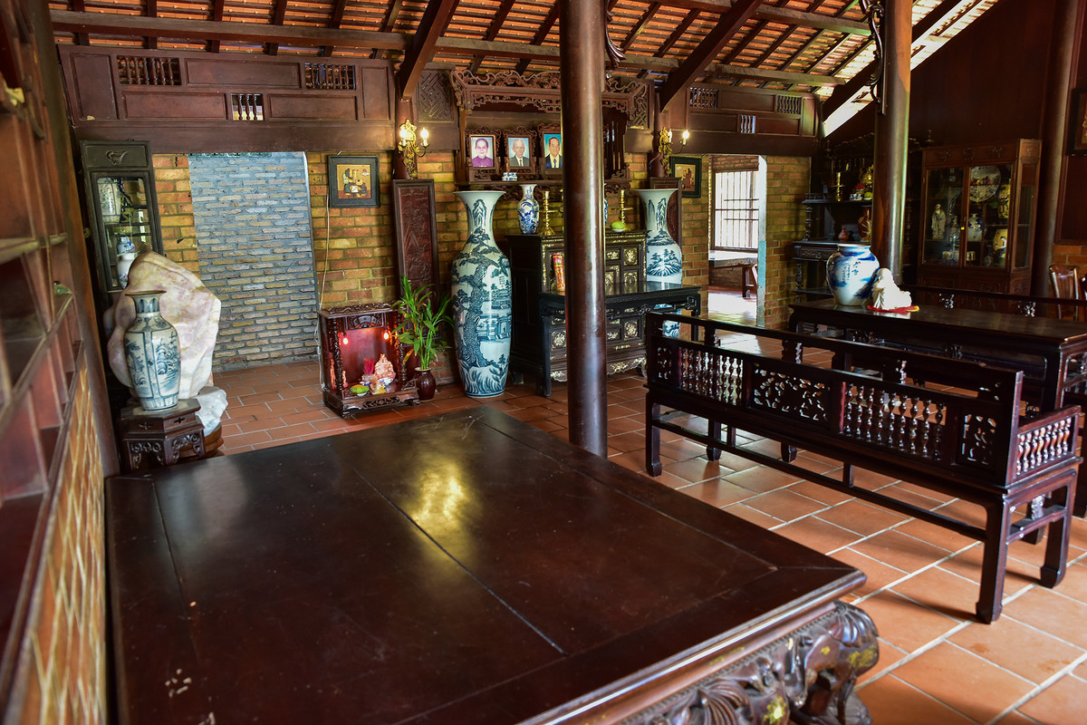 Căn nhà được dựng từ 54 cột gỗ gõ mật. Gian chính rộng 60m2, với đầy đủ nội thất đặc trưng như bộ trường kỷ, phản, bộ bàn ghế ăn cơm, án thờ....Ảnh: Dân Việt
