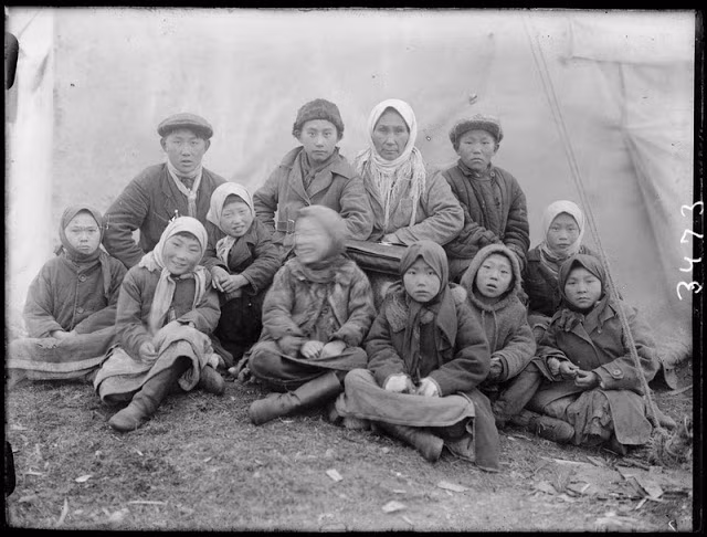 Những em bé Siberia chụp ảnh bên ngoài một túp lều.