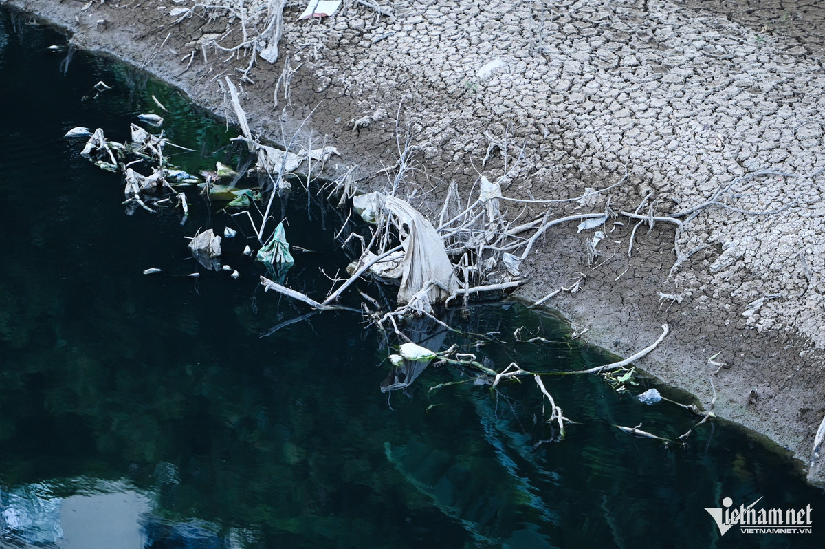 Hình ảnh sông Nhuệ với dòng nước đen thẫm, hai bên bờ sông nứt nẻ mất sự sống.