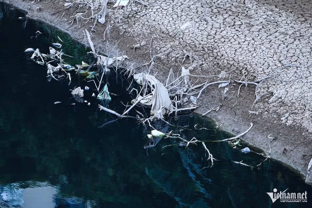 Hình ảnh sông Nhuệ với dòng nước đen thẫm, hai bên bờ sông nứt nẻ mất sự sống.