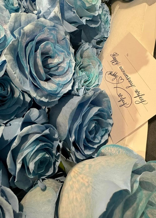 Cô nhận hoa và thiệp chúc mừng ngày kỷ niệm từ bạn đời.