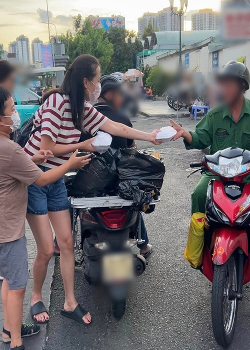 Con trai Ái Châu được bố mẹ dẫn đi làm từ thiện trong tháng 7.