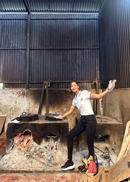 H'hen Niê ăn mặc giản dị khi nấu ăn trong một chuyến thiện nguyện.