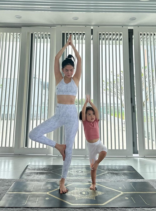 Nữ người mẫu cùng bé He tập yoga.