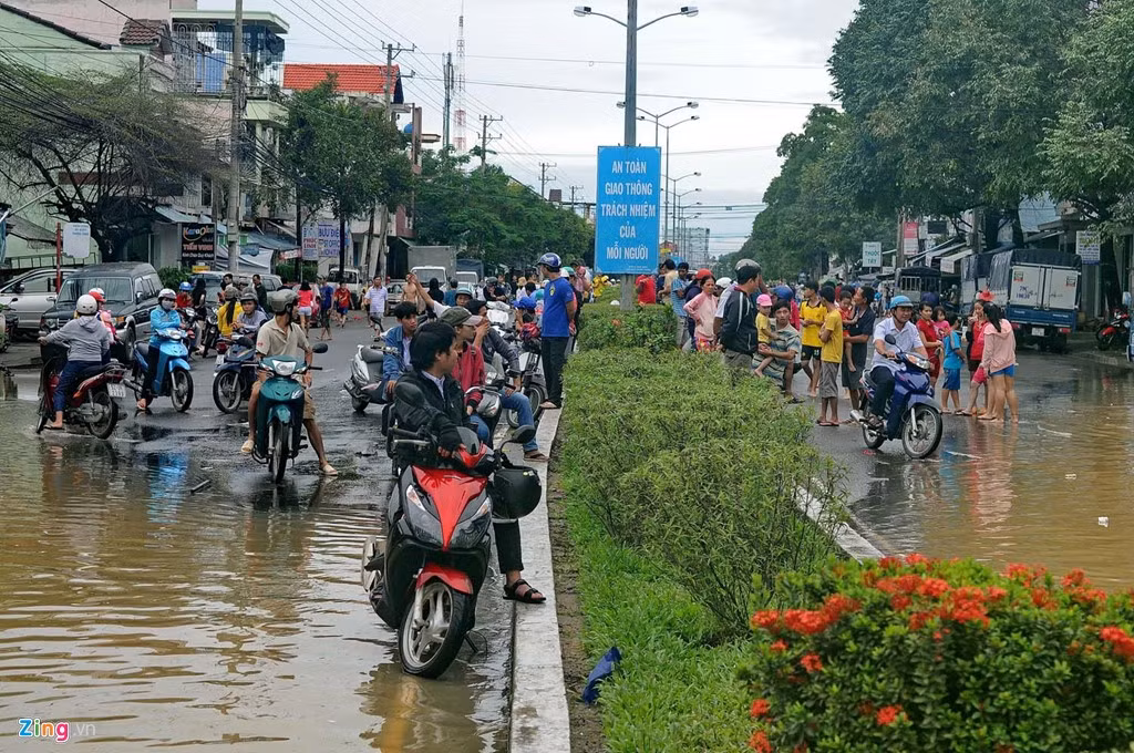 Người dân ở huyện Diên Khánh đi làm tại Nha Trang ngồi chờ nước rút để về nhà.