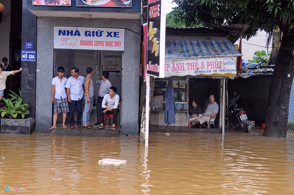 Người dân ngán ngẩm ngồi trong nhà nhìn ra ngoài.
