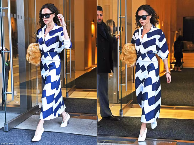 Bà Beck diện bộ váy họa tiết xanh trắng, một thiết kế trong bộ sưu tập mới của Victoria và cầm tay chiếc clutch lông. (Ảnh: Splash News)