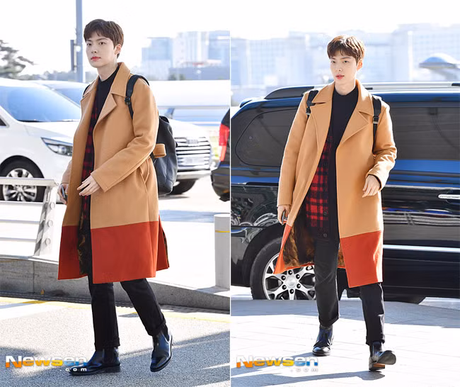 Nam diễn viên Ahn Jae Hyun nổi bật ở sân bay với chiếc áo dạ hai màu vàng cam.