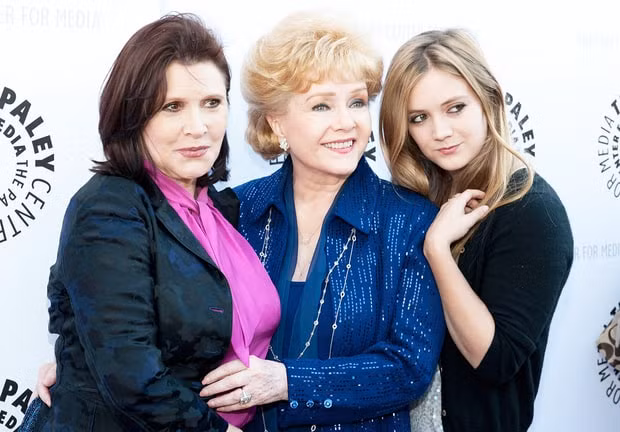 Ba thế hệ nhà Carrie Fisher gồm mẹ bà, Carrie và con gái Billie Lourd đều là diễn viên. Carrie sinh con gái duy nhất vào tháng 7/1992. Ba năm sau, chồng cũ của Carrie và bố của Billie, Bryan Lourd, tuyên bố là lưỡng tính. (Ảnh: Getty Images)
