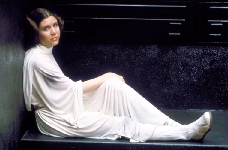 Fan luôn nhớ tới Carrie Fisher là công chúa Leia trong Star Wars. “Dù có chuyện gì xảy ra thì tôi vẫn là công chúa Leia. Công chúa Leia sẽ theo tôi tới tận xuống mồ” – Fisher từng đùa như vậy. (Ảnh: People)