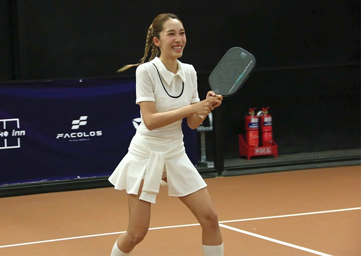 Trên sân pickleball, Emily diện trang phục năng động, tràn đầy sức sống.