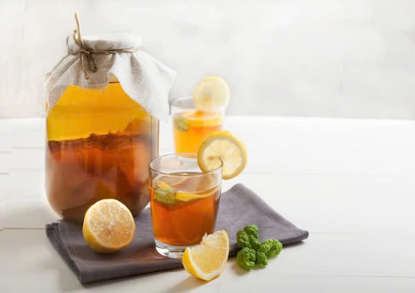 Kombucha là một loại trà xanh hoặc đen lên men cùng với trái cây cung cấp men vi sinh có lợi. Nó kết hợp các lợi ích sức khỏe của trà, cộng với các lợi ích sức khỏe bổ sung liên quan đến men vi sinh, bao gồm cải thiện hệ vi sinh vật đường ruột. Probiotic có thể làm giảm sự hấp thụ chất béo từ thức ăn, tăng cường hormone điều chỉnh sự thèm ăn để giúp hạn chế ăn quá nhiều và có thể giảm bớt tình trạng viêm nhiễm cũng liên quan đến mỡ thừa và mỡ bụng. Tuy nhiên, thức uống này cũng có chứa đường, vì vậy uống quá nhiều không phù hợp cho quá trình giảm cân. Để kombucha được phát huy hiệu quả nhất, chỉ nên uống 240ml mỗi ngày.
