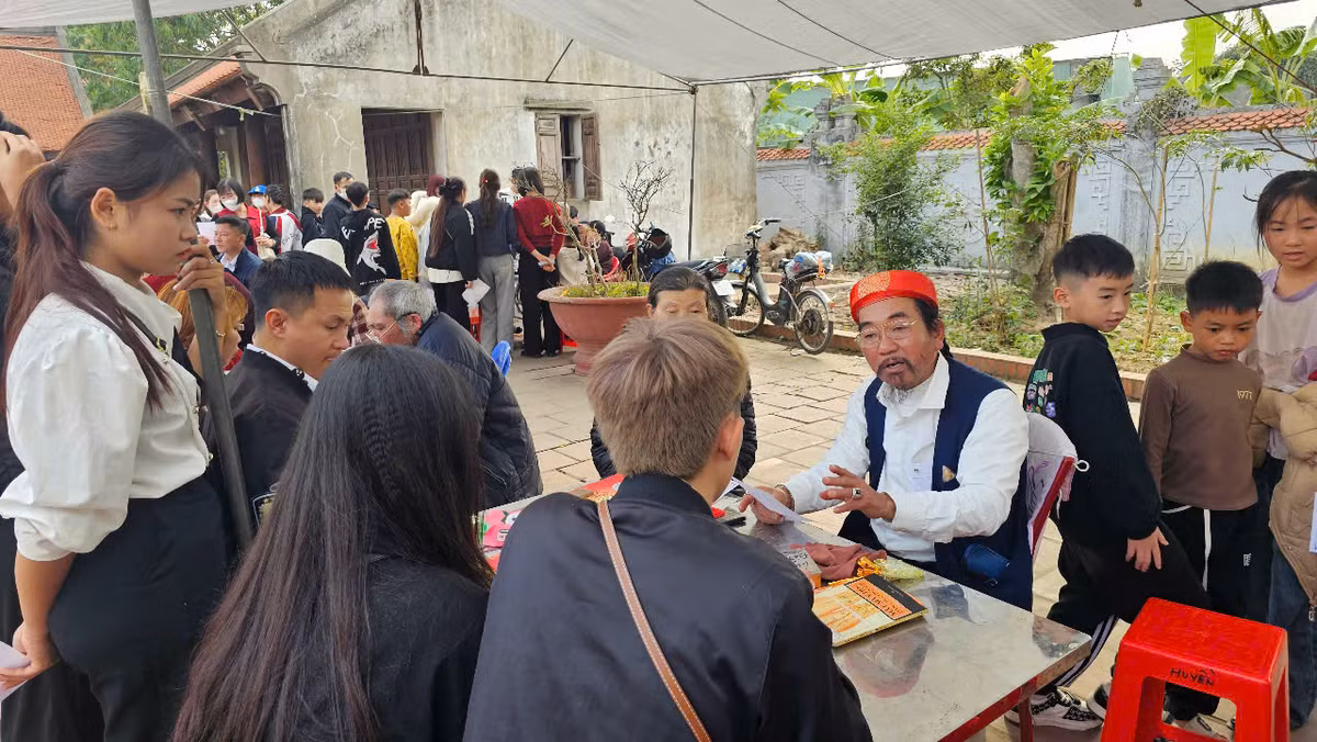 Du khách nhờ người luận quẻ thẻ tại đền.