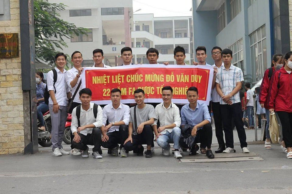 Văn Duy bên cạnh tấm băng rôn được các bạn làm tặng. (Ảnh: Tổng hợp Facebook)