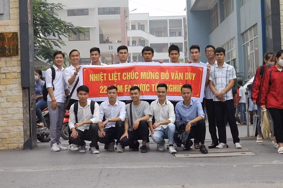 Văn Duy bên cạnh tấm băng rôn được các bạn làm tặng. (Ảnh: Tổng hợp Facebook)