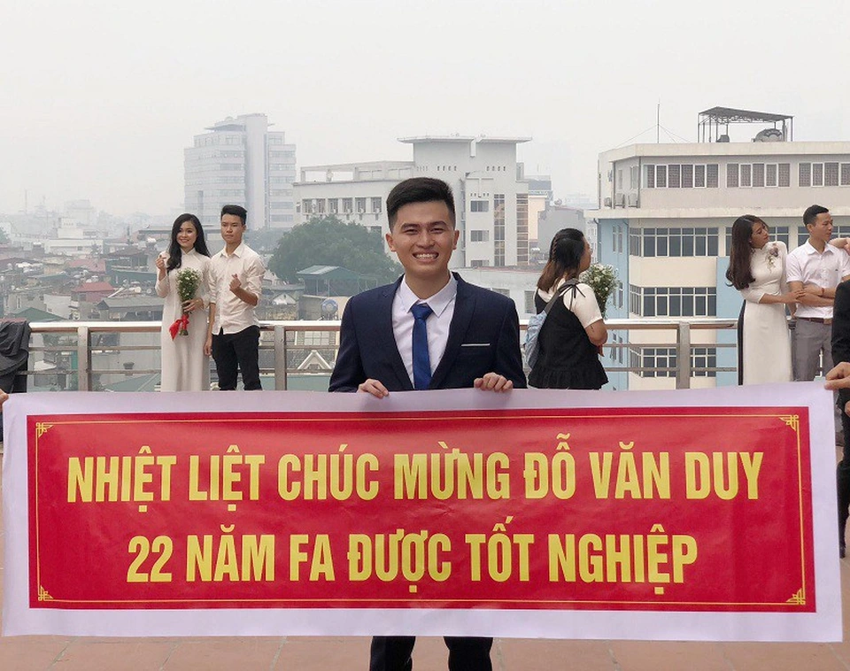 Để kỷ niệm ngày chuẩn bị tốt nghiệp, trong buổi chụp hình kỷ yếu, các bạn thân cùng phòng đã tâm lý chuẩn bị cho Văn Duy một tấm băng rôn với dòng chữ: “Nhiệt liệt chúc mừng Đỗ Văn Duy 22 năm FA được tốt nghiệp”. (Ảnh: Tổng hợp Facebook)