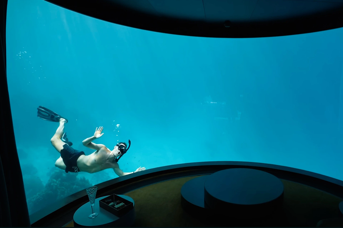 Phòng còn có khu vực ghế ngồi kiểu "rạp hát" nhìn ra biển. Từ đây, các bạn sẽ được ngắm nhìn bạn bè lặn tự do cùng các đàn cá bên ngoài ô cửa kính. Tuy nhiên, cặp đôi nhận xét rằng nhà vệ sinh với tầm nhìn hướng ra rạn san hô là "chỗ ngồi tốt nhất trong căn phòng". Ảnh: Kara and Nate.