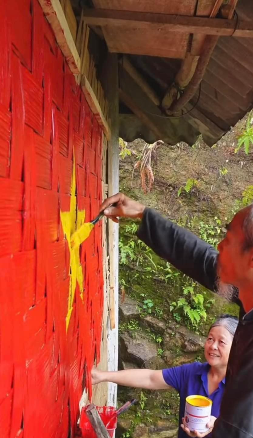 Trên vách phên nứa của ngôi nhà nhỏ, một chiếc cờ đỏ sao vàng dần dần hiện ra.