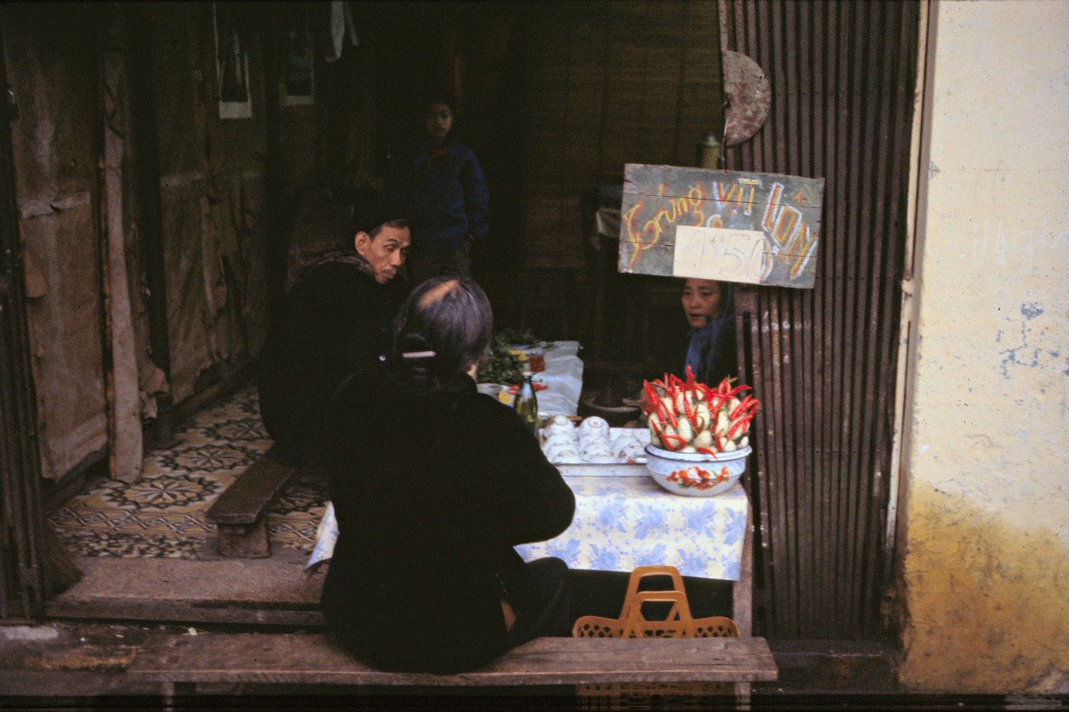 Một quán bán trứng vịt lộn quen đường. Có thể thấy những vật dụng xưa quen thuộc từ thời cha ông như chiếc ni lông trải bàn, băng ghế gỗ dài cho khách ngồi, hay tấm bảng "Trứng vịt lộn" được ghi bằng phấn màu.