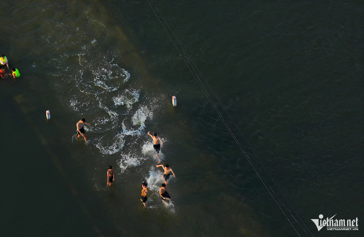 Một tuần qua, đường làng và hai bên cánh đồng gần Trung tâm Văn hóa thôn Cấn Hạ, xóm Bến Vôi (xã Cấn Hữu, huyện Quốc Oai, Hà Nội) trở thành điểm bơi lội vào mỗi buổi chiều của người dân quanh vùng. Ảnh: Vũ Minh Quân.