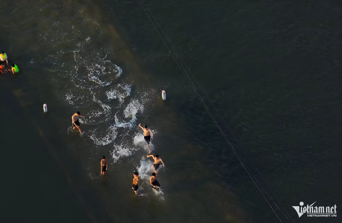 Một tuần qua, đường làng và hai bên cánh đồng gần Trung tâm Văn hóa thôn Cấn Hạ, xóm Bến Vôi (xã Cấn Hữu, huyện Quốc Oai, Hà Nội) trở thành điểm bơi lội vào mỗi buổi chiều của người dân quanh vùng. Ảnh: Vũ Minh Quân.