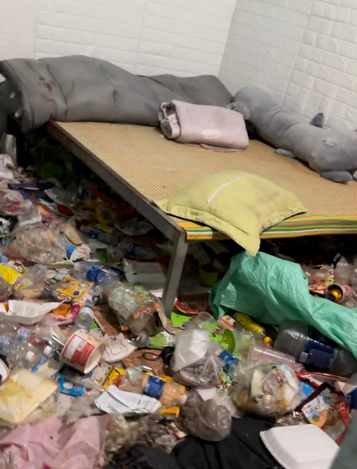 Quan sát khắp một lượt, có thể thấy cả căn phòng ngập trong rác thải, chắn hết lối đi lại. Bên dưới sàn nhà có nhiều vỏ hộp cơm – cho thấy chủ nhân cũ của căn phòng cũng lười nấu ăn lắm.