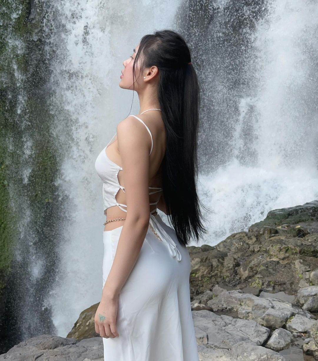 Trong loạt ảnh, cô gái diện đồ màu trắng với chất liệu lụa mỏng manh, khoe trọn bờ lưng trần gợi cảm cùng thân hình đồng hồ cát.