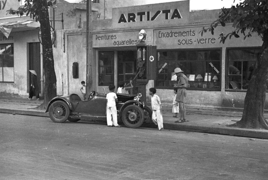 Hanoi 1940 – Children filling a car with gasoline.