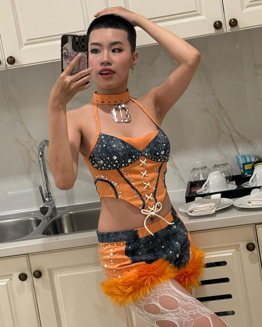 Điển hình như outfit cô nàng lựa chọn gần đây trong một buổi biểu diễn. Set đồ với màu sắc tương phản cam - đen cực nổi bật kết hợp cùng mái tóc kiểu "đầu đinh" cực chiến giúp cô nàng trông vô cùng cá tính.