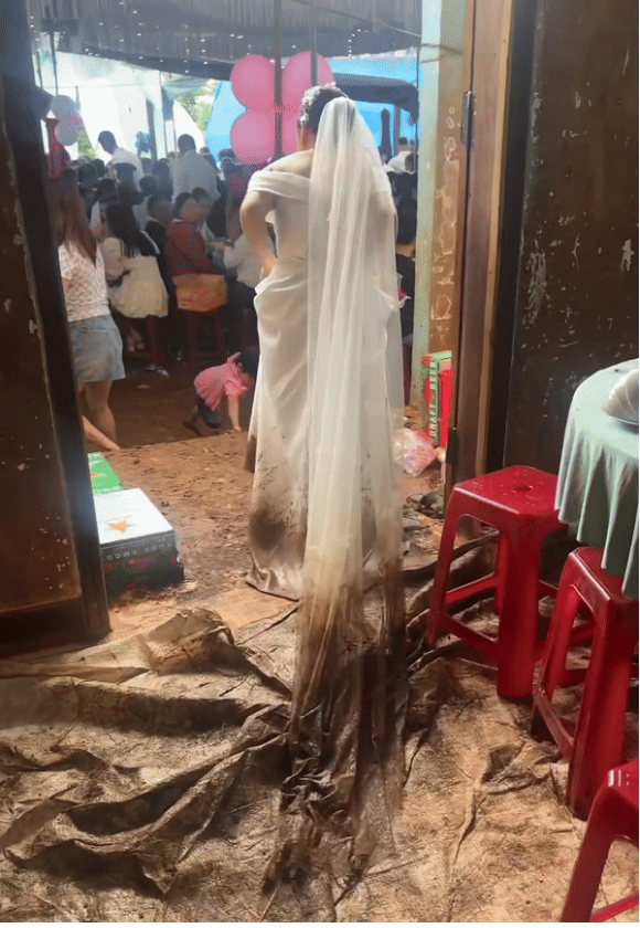 Mặc dù chú rể đi theo giúp cầm khăn voan cho vợ nhưng chẳng đáng kể là bao. Vì phải đi trong bùn đất, tay xách váy nên cô dâu đi lại khó khăn, đôi khi còn như suýt ngã.