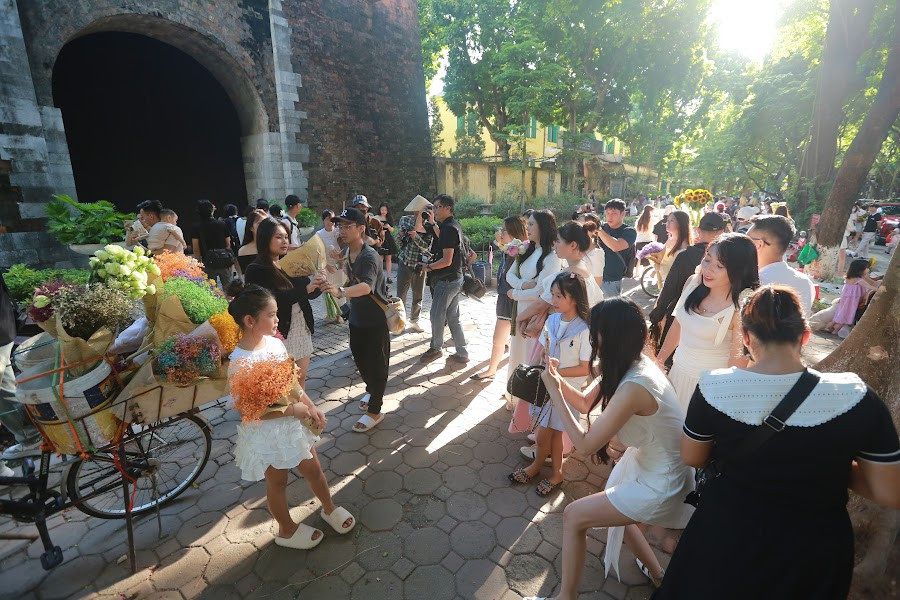 Thế nhưng do số lượng người quá đông, rất nhiều người mua hoa xong phải đứng chờ để đến lượt mình chụp với xe hoa.