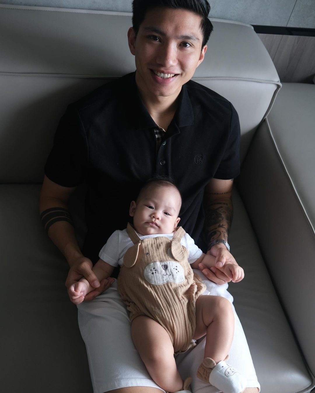 "Rồng con" được mẹ chuẩn bị trang phục giản dị với chiếc yếm màu nâu hình mặt cún vô cùng đáng yêu.