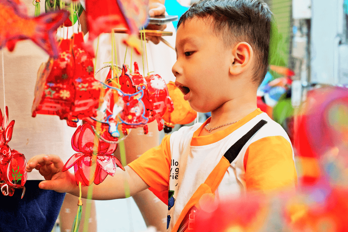 Các em nhỏ xúng xính váy áo được ba mẹ dắt đến để tự tay lựa chọn những chiếc lồng đèn ưng ý.