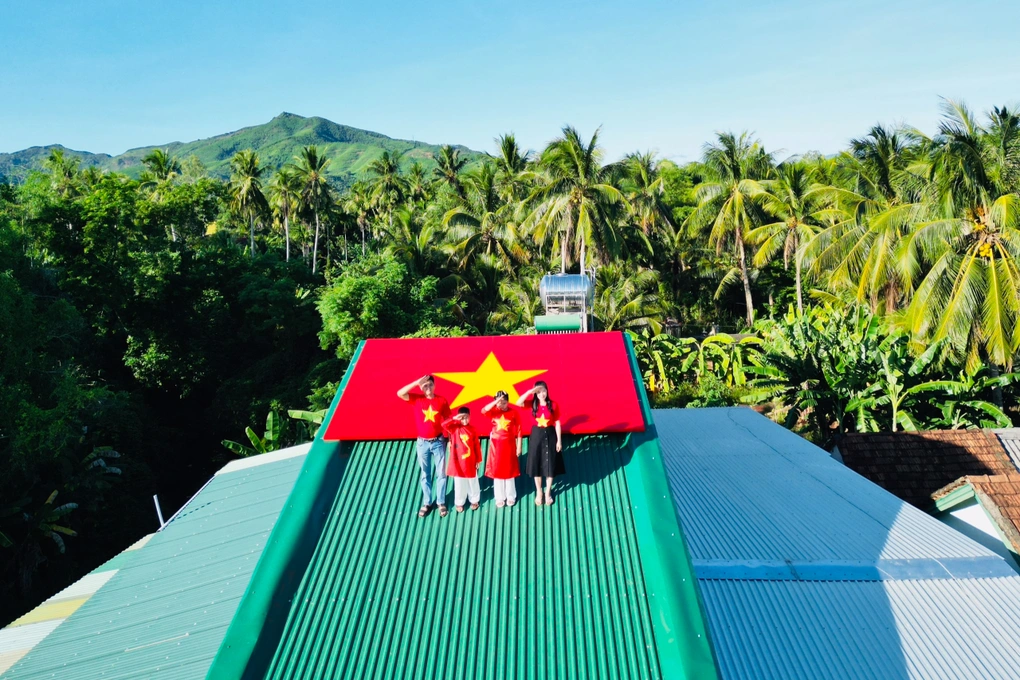 Sáng 13/8, gia đình 4 thành viên của chị Nguyễn Thị Thanh Tuyền (36 tuổi) mặc áo dài đỏ và áo cờ đỏ sao vàng, lên mái nhà chụp ảnh cùng lá cờ Tổ quốc đặc biệt.