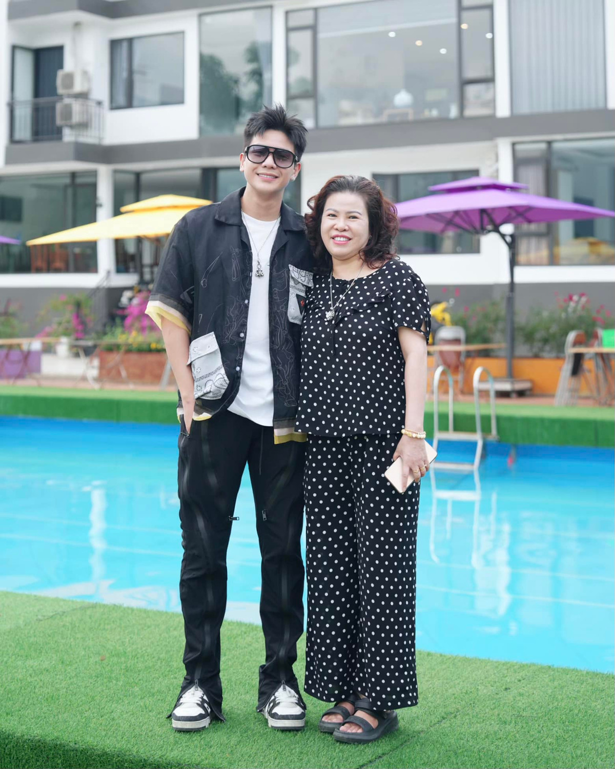 Khung cảnh phía sau Quân A.P và mẹ chính là khu villa của gia đình. Được biết, cơ ngơi này do mẹ anh quản lý.