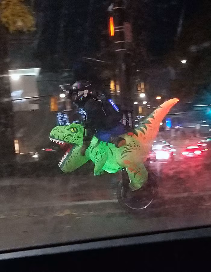 Một anh chàng cưỡi "khủng long" trên đường phố vào buổi tối.